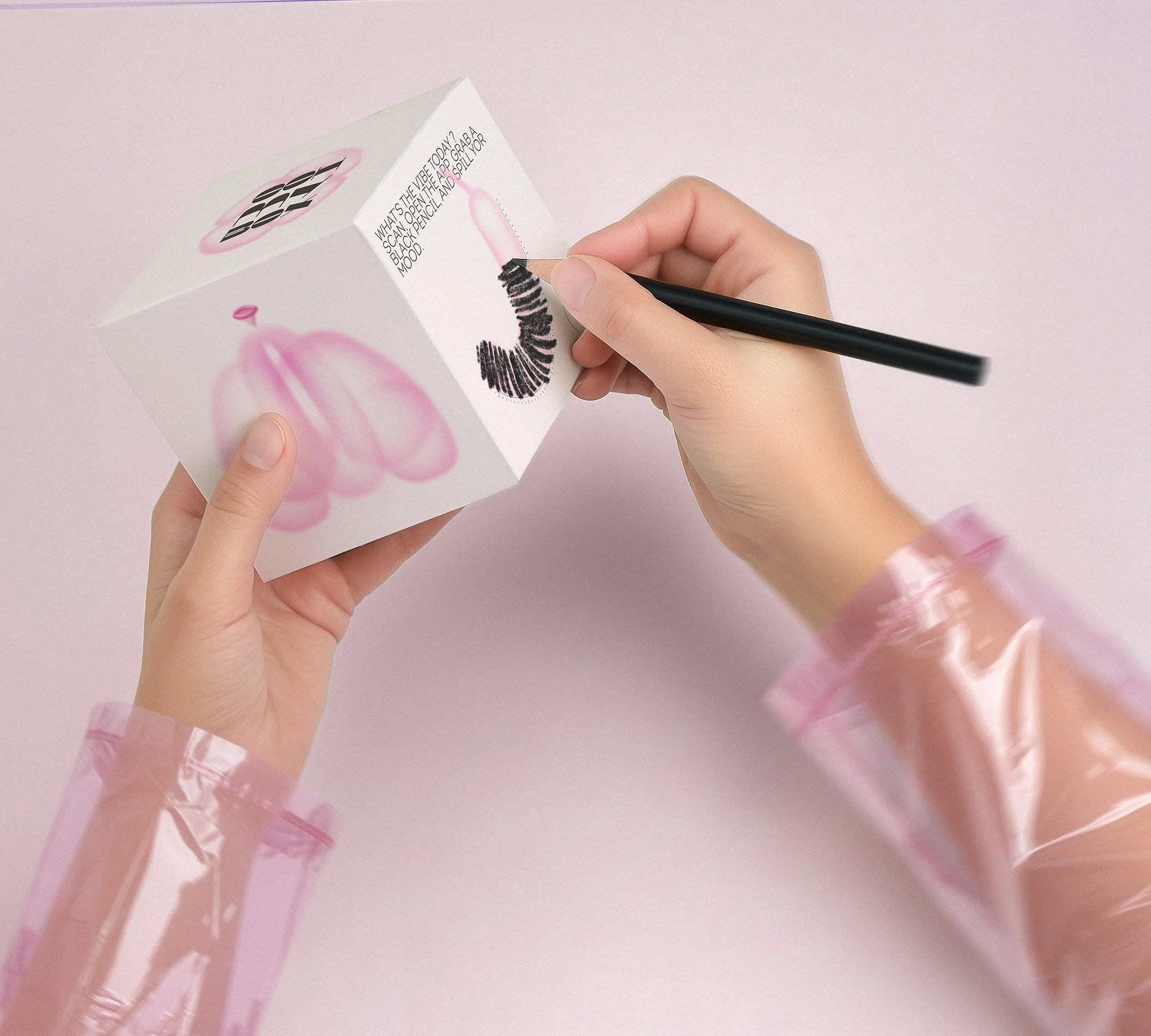 Hands holding the Oh My Box! package and drawing on it with a black pencil, personalising the interactive surface.